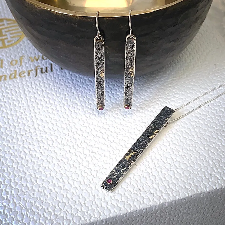 Solid sterling silver and gold earrings set with deep pink Rubies.